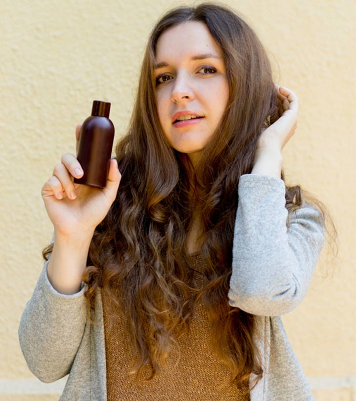 Women with gray hair holding some hair oil container Women with gray hair holding some hair oil container