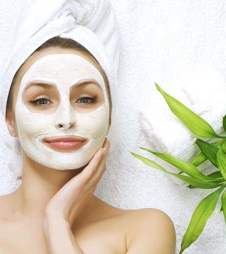 A girl applied a face pack and some green leaves present beside her