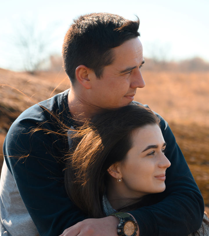 A guy holding his partner from behind