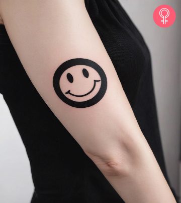 A woman with a smiley face tattoo on her arm A woman with a smiley face tattoo on her arm