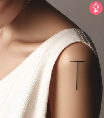 A woman wearing a ‘T’ style letter tattoo on the upper arm. A woman wearing a ‘T’ style letter tattoo on the upper arm.