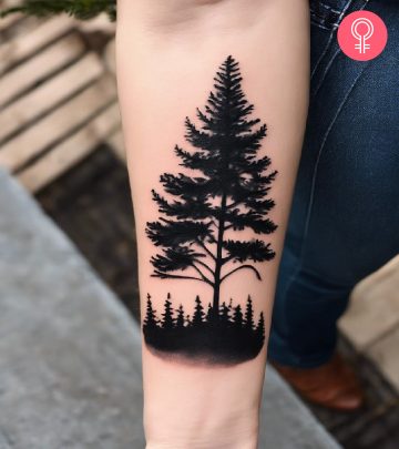 A black ink evergreen tree tattoo on the forearm A black ink evergreen tree tattoo on the forearm