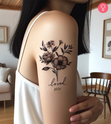 A memorial tattoo on the upper arm of a woman A memorial tattoo on the upper arm of a woman