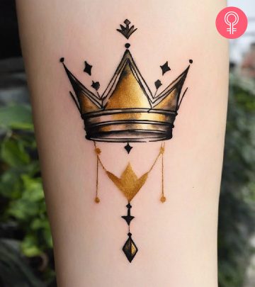 A minimalist watercolor golden crown tattoo on the arm A minimalist watercolor golden crown tattoo on the arm