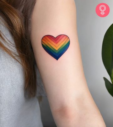 A rainbow-colored heart tattoo on the inner upper arm of a woman A rainbow-colored heart tattoo on the inner upper arm of a woman