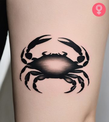 A woman with a minimalist crab tattoo on her upper arm A woman with a minimalist crab tattoo on her upper arm