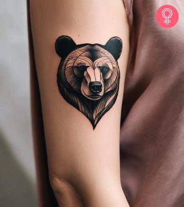 Bear tattoo on a woman’s upper arm Bear tattoo on a woman’s upper arm