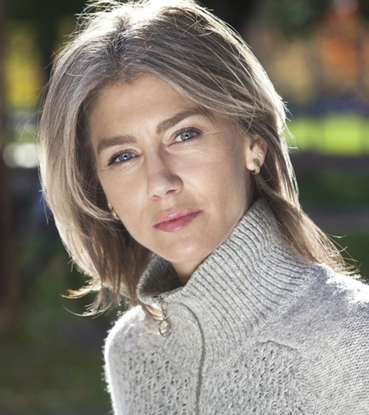 Person With Gray Hair Looking At A Bottle Of Coconut Oil Person With Gray Hair Looking At A Bottle Of Coconut Oil