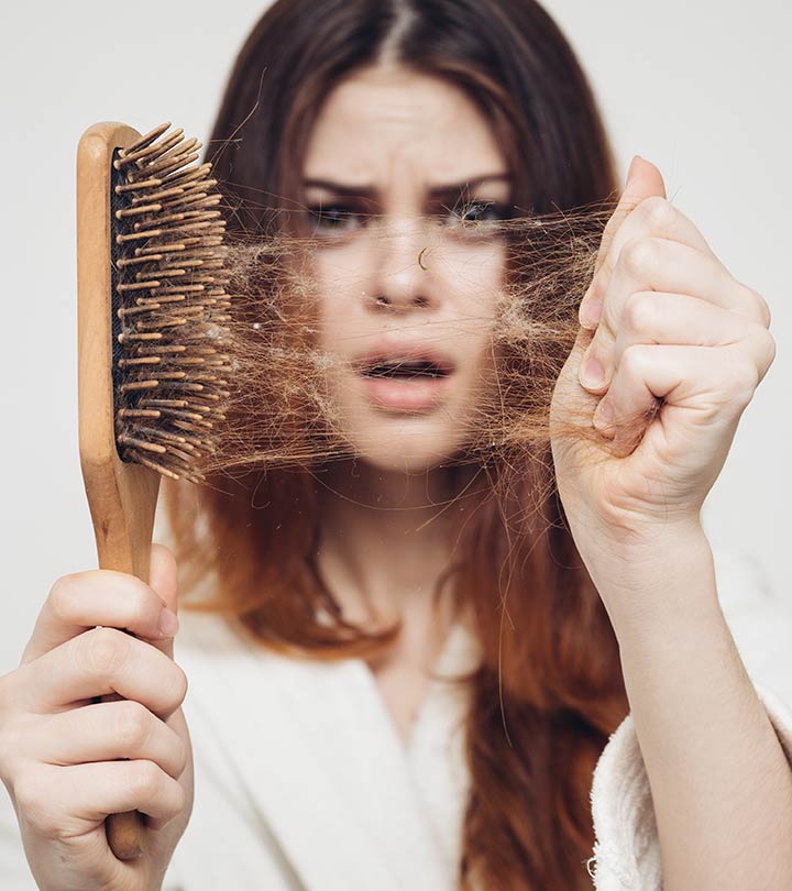 A woman with hairfall on a comb