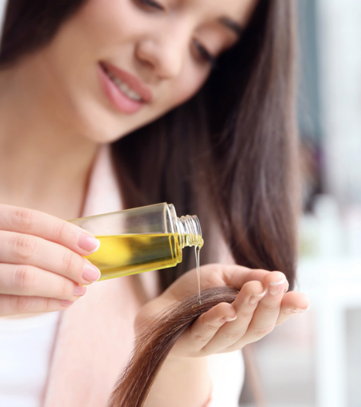 Women Applying Oil To Her Hair