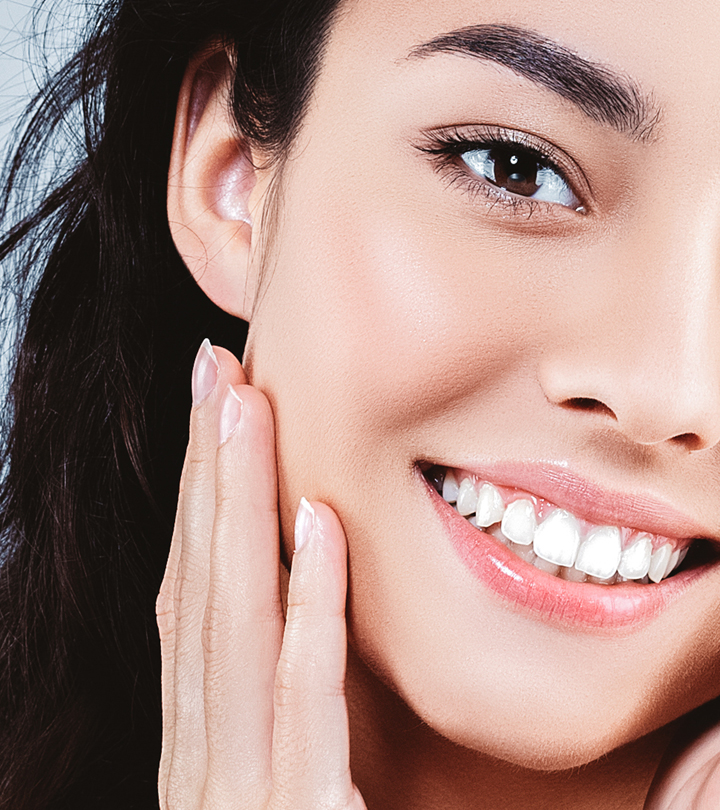 A smiling girl touching her face