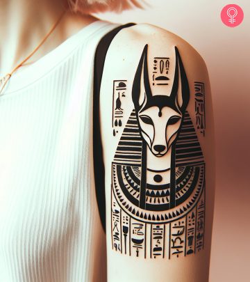 A woman with an Anubis and hieroglyphics tattoo on the upper arm