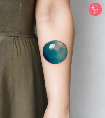 8 Creative and Colorful Bubble Tattoo Ideas A woman wearing a ‘T’ style letter tattoo on the upper arm.